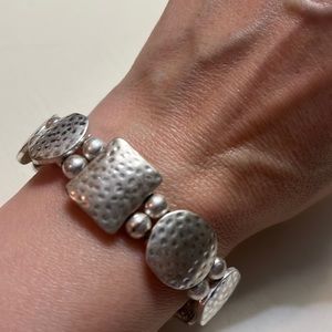 Br8. Silver colored bracelet.
